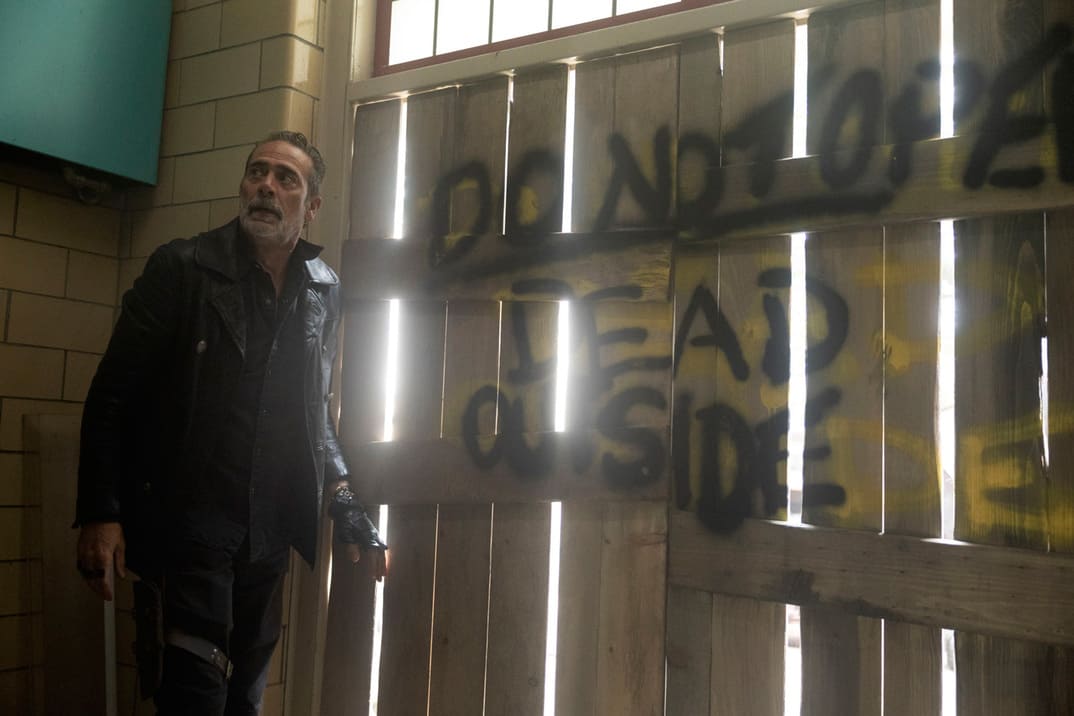 "The Walking Dead: Dead City" 1x06 - Negan de pie ante una puerta que hace un guiño a la serie original con el texto "Do not open, dead outside"