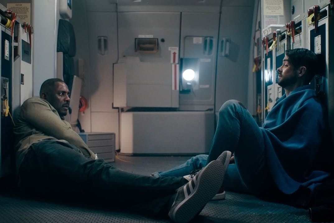 "Secuestro en el aire" 1x05 - imagen del personaje de Idris Elba tumbado en el suelo hablando con el secuestrador herido
