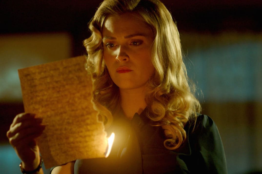 Imagen promocional de Eliza Taylor quemando una carta en "Quantum leap"temporada 2 - entrada