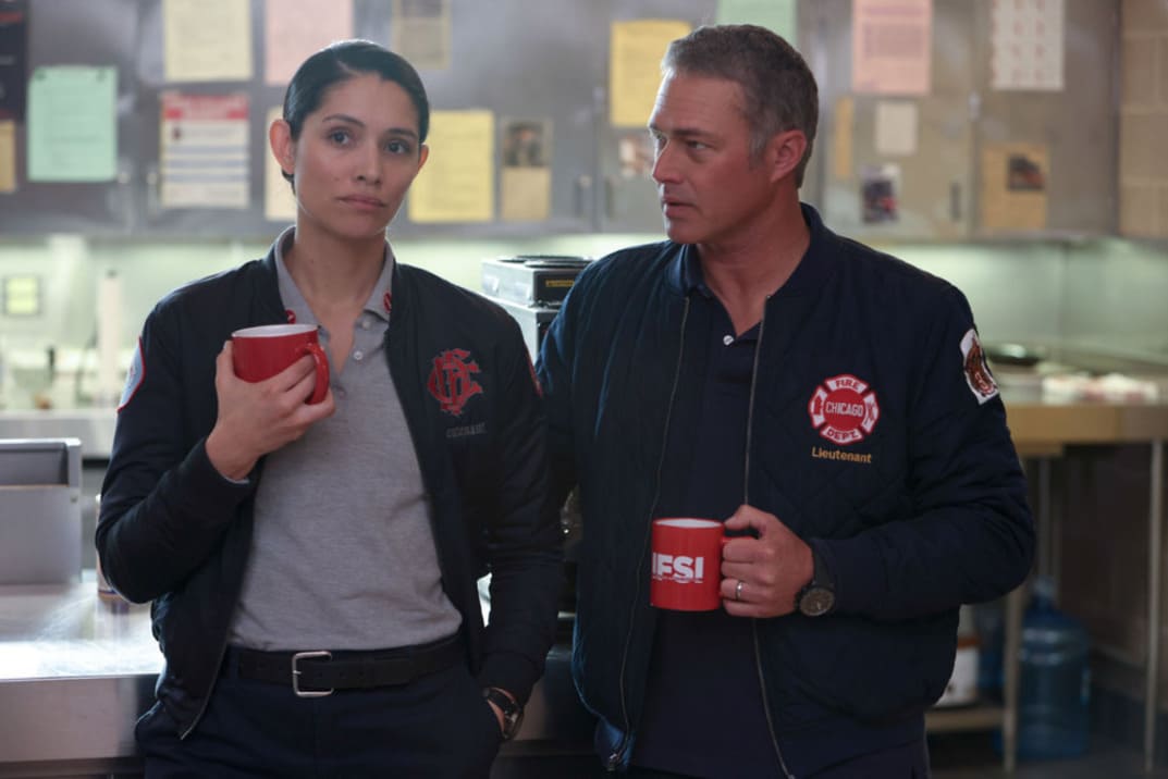 Imagen promocional de "Chicago Fire" 12x03 - Stella y Severide cada uno con una taza de café en la mano hablan en la estación
