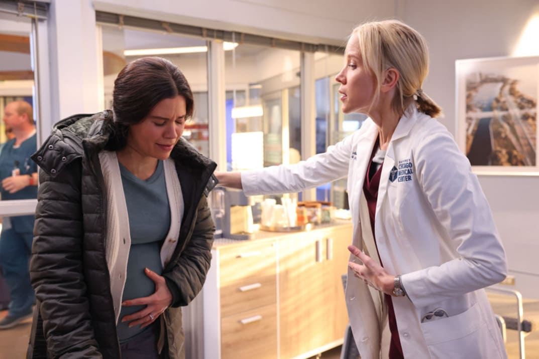 Imagen promocional de "Chicago Med" 9x04 - Hannah con el brazo apoyado sobre una paciente embarazada trata de calmarla