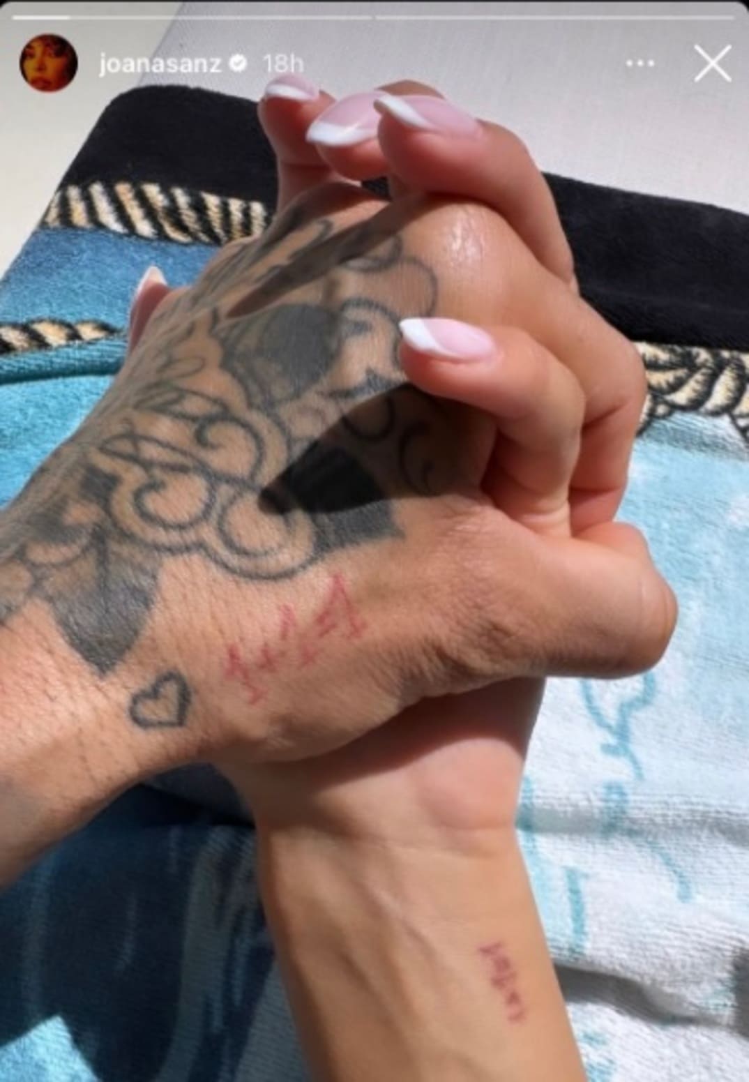 Imagen de la mano de Dani Alves con los dedos entrelazados a la mano de Joana Sanz