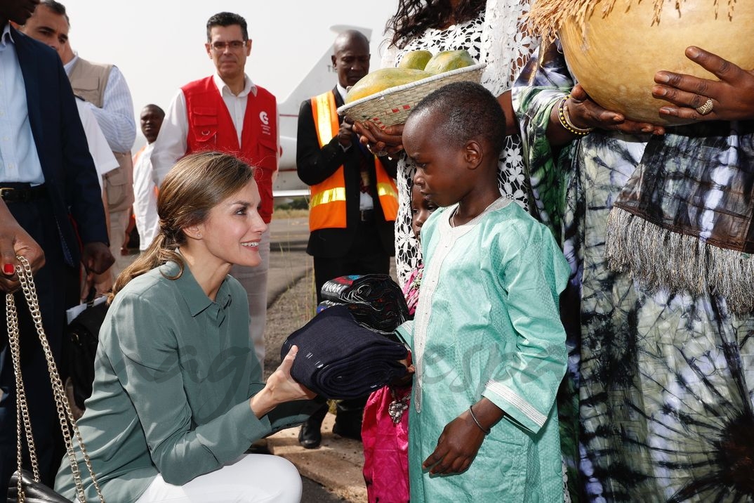 La Reina recibe un obsequio de un niño a su llegada a Ziguinchor © Casa S.M. El Rey